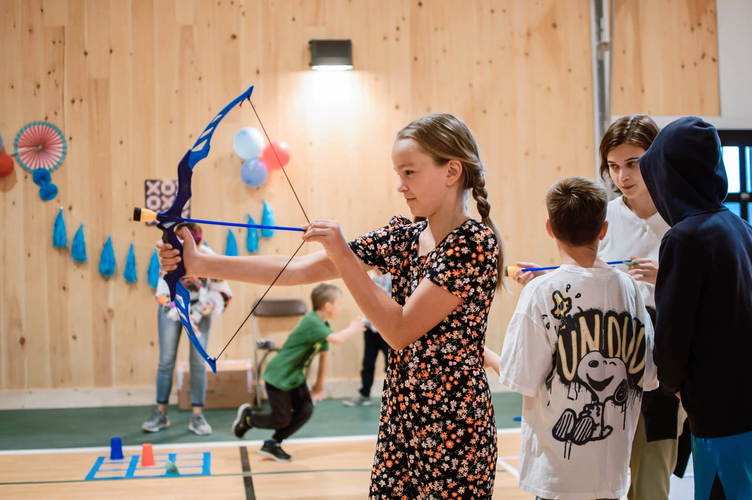 Girl shooting with an arrow toy